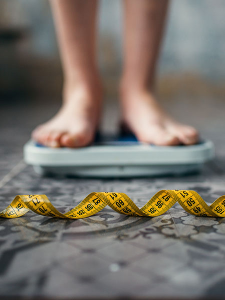 womans-feet-scales-measuring-tape-fat-calories-burning-concept-weight-loss-hard-dieting