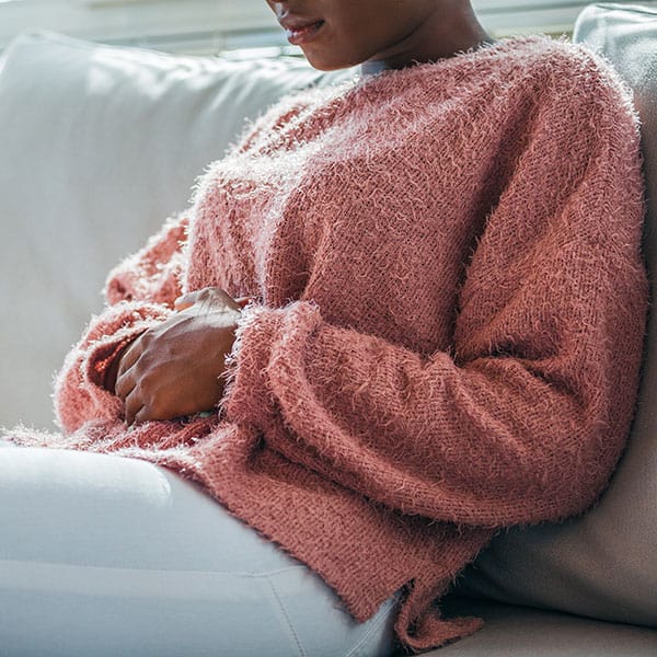 woman-with-stomach-ache-lying-sofa