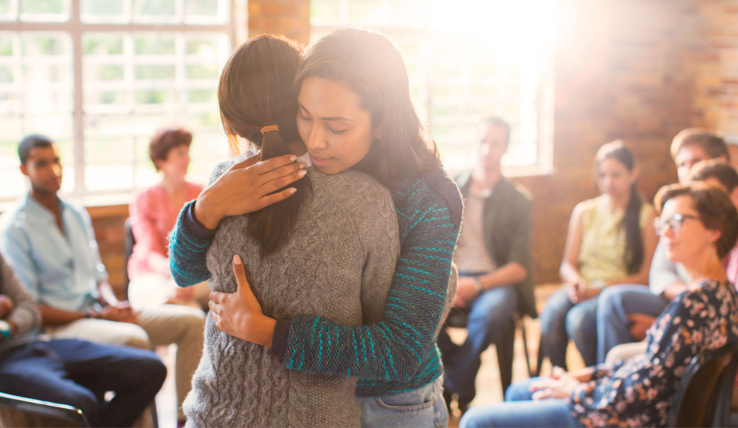 two people embracing group therapy